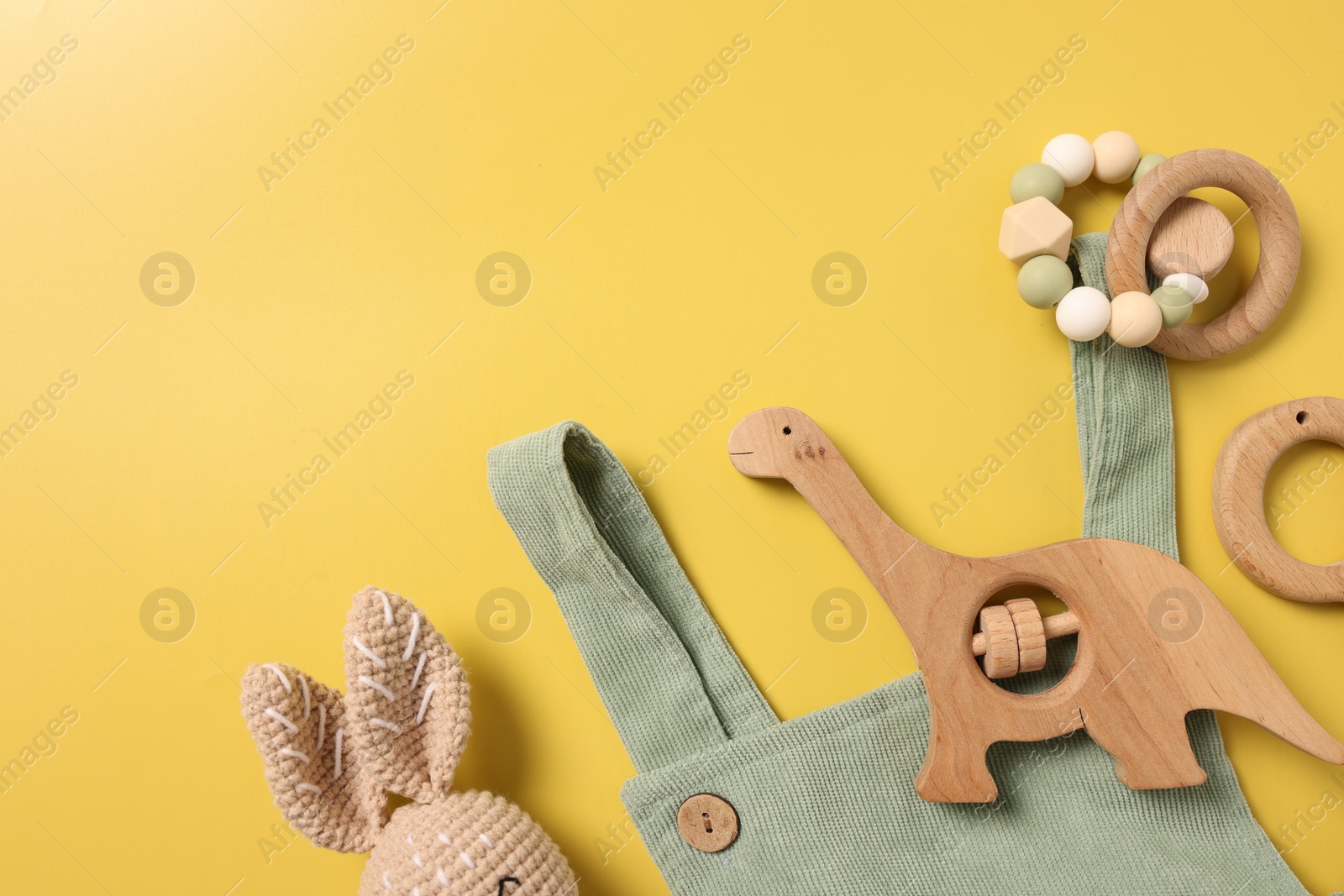Photo of Different baby accessories on yellow background, flat lay. Space for text