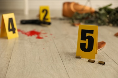 Photo of Crime scene markers and casings on floor indoors