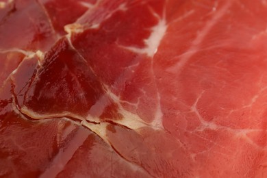 Photo of Delicious sliced jamon as background, closeup view