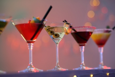 Different martini cocktails on table against blurred background