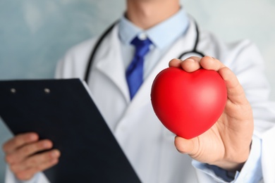 Photo of Doctor holding red heart, closeup view. Cardiology concept