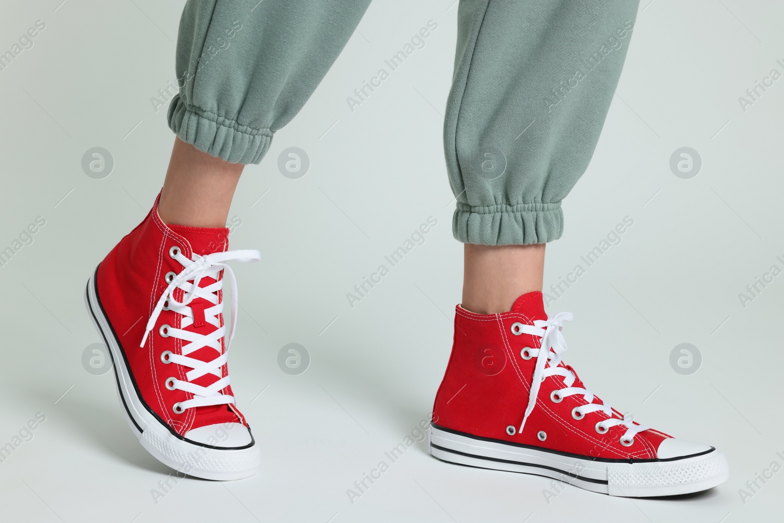 Photo of Woman in stylish gumshoes on white background, closeup