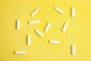 Photo of Tampons on yellow background, flat lay. Menstrual hygiene product