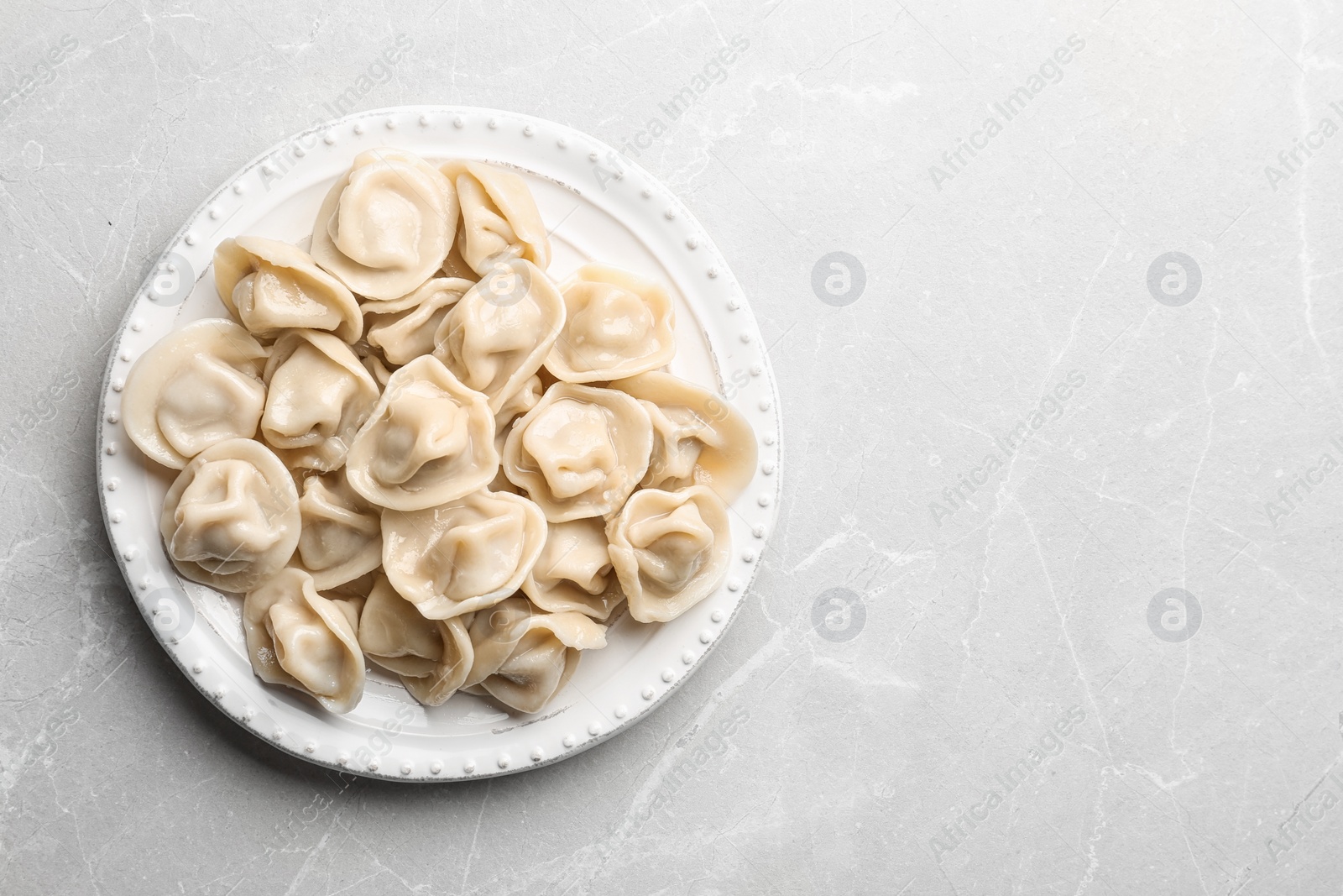 Photo of Tasty dumplings on marble table, top view. Space for text