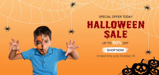 Image of Halloween sale ad design. Little boy with half face painted as spooky pumpkin on orange background