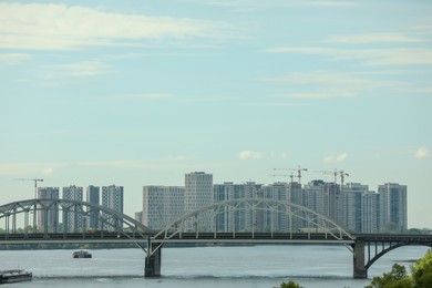 Beautiful view of cityscape with modern buildings and bridge over river