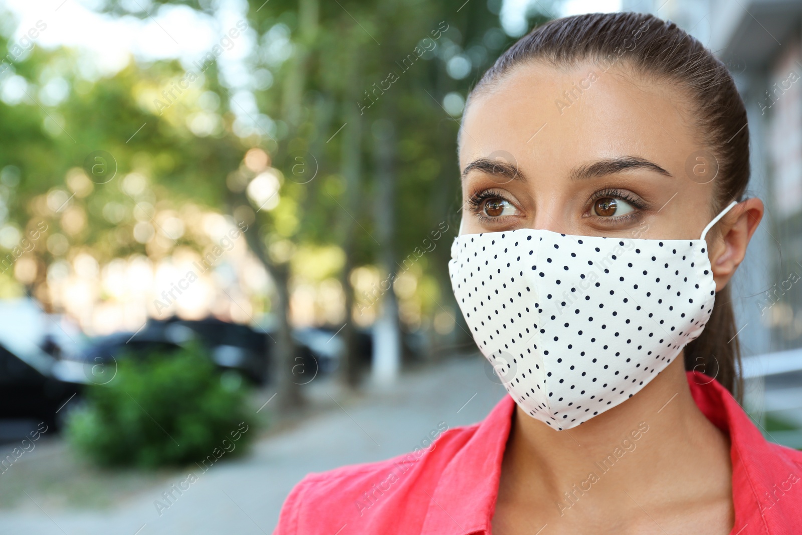 Photo of Woman wearing handmade cloth mask outdoors, space for text. Personal protective equipment during COVID-19 pandemic