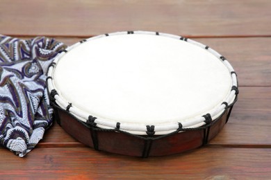 Photo of Modern drum on wooden table. Musical instrument