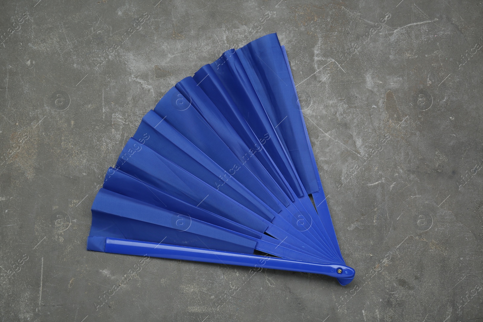 Photo of Bright blue hand fan on grey background, top view