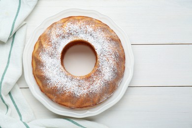 Homemade yogurt cake with powdered sugar on white wooden table, top view. Space for text