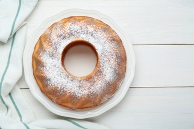 Photo of Homemade yogurt cake with powdered sugar on white wooden table, top view. Space for text