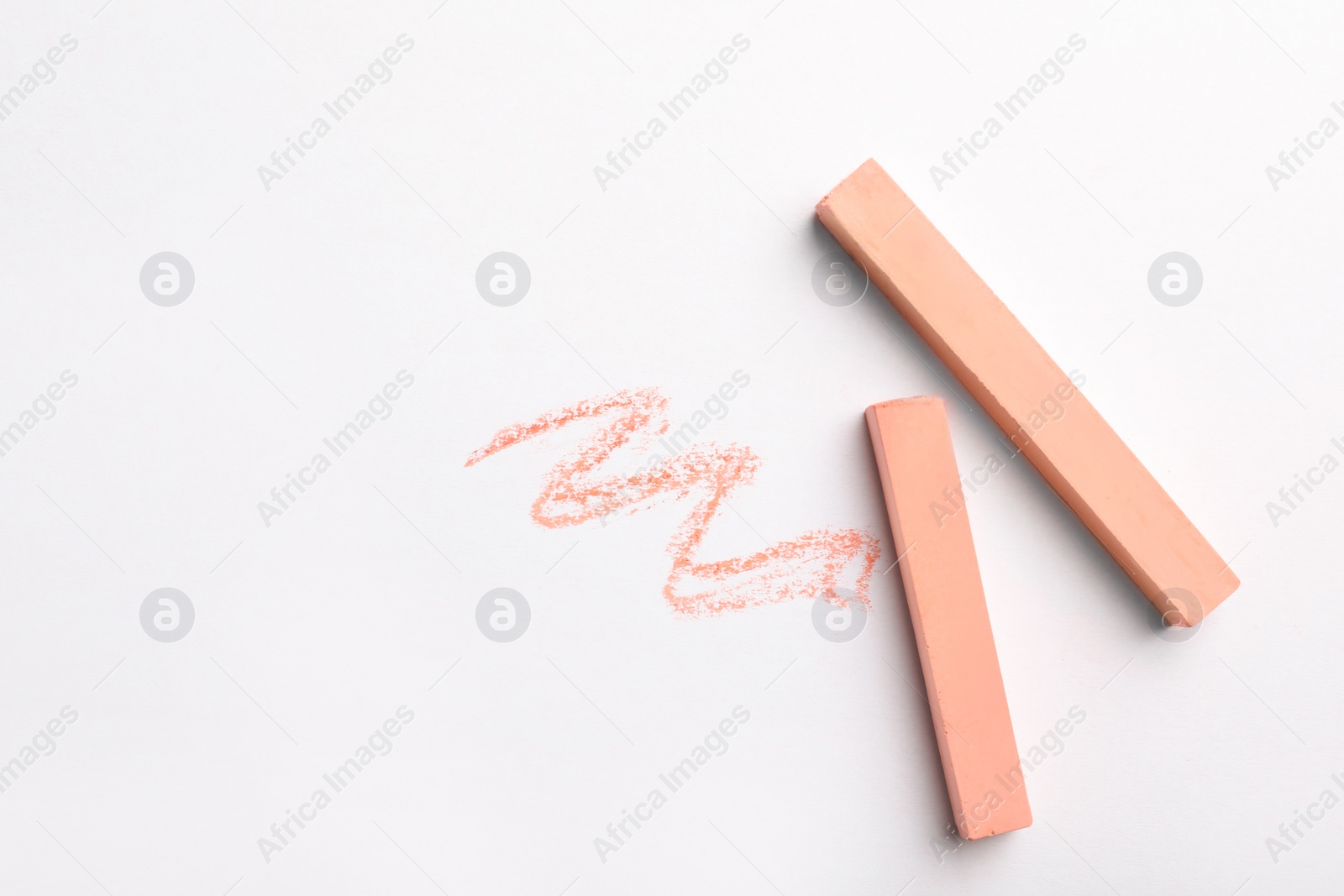 Photo of Coral chalk sticks on white background, top view