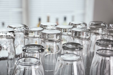 Photo of Empty glasses on table against blurred background, closeup