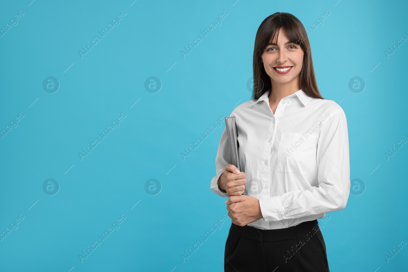 Photo of Happy secretary with folder on light blue background. Space for text