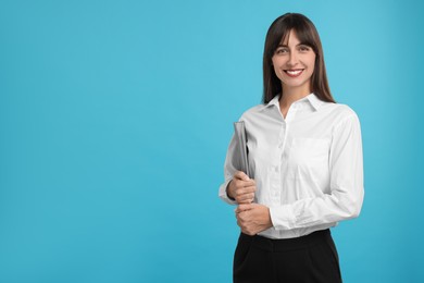 Photo of Happy secretary with folder on light blue background. Space for text
