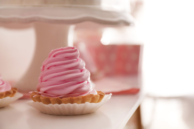 Photo of Delicious cake with pink cream for birthday party on white table, closeup. Space for text