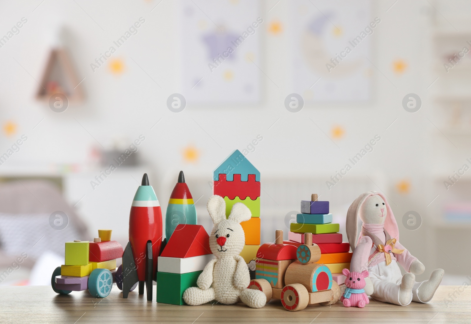 Image of Set of different cute toys on wooden table in children's room