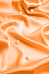 Image of Many beautiful pearls on delicate orange silk