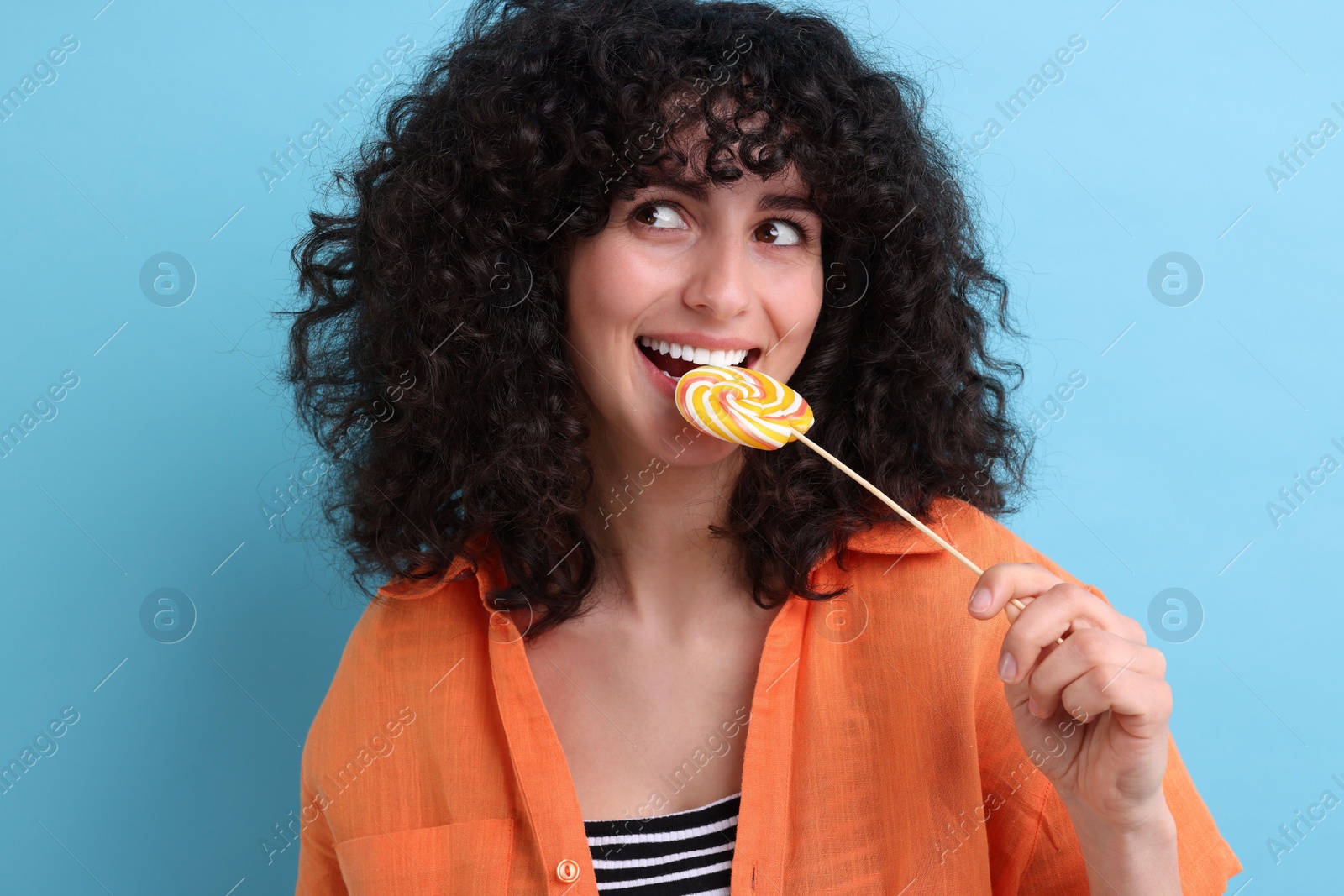 Photo of Beautiful woman with lollipop on light blue background