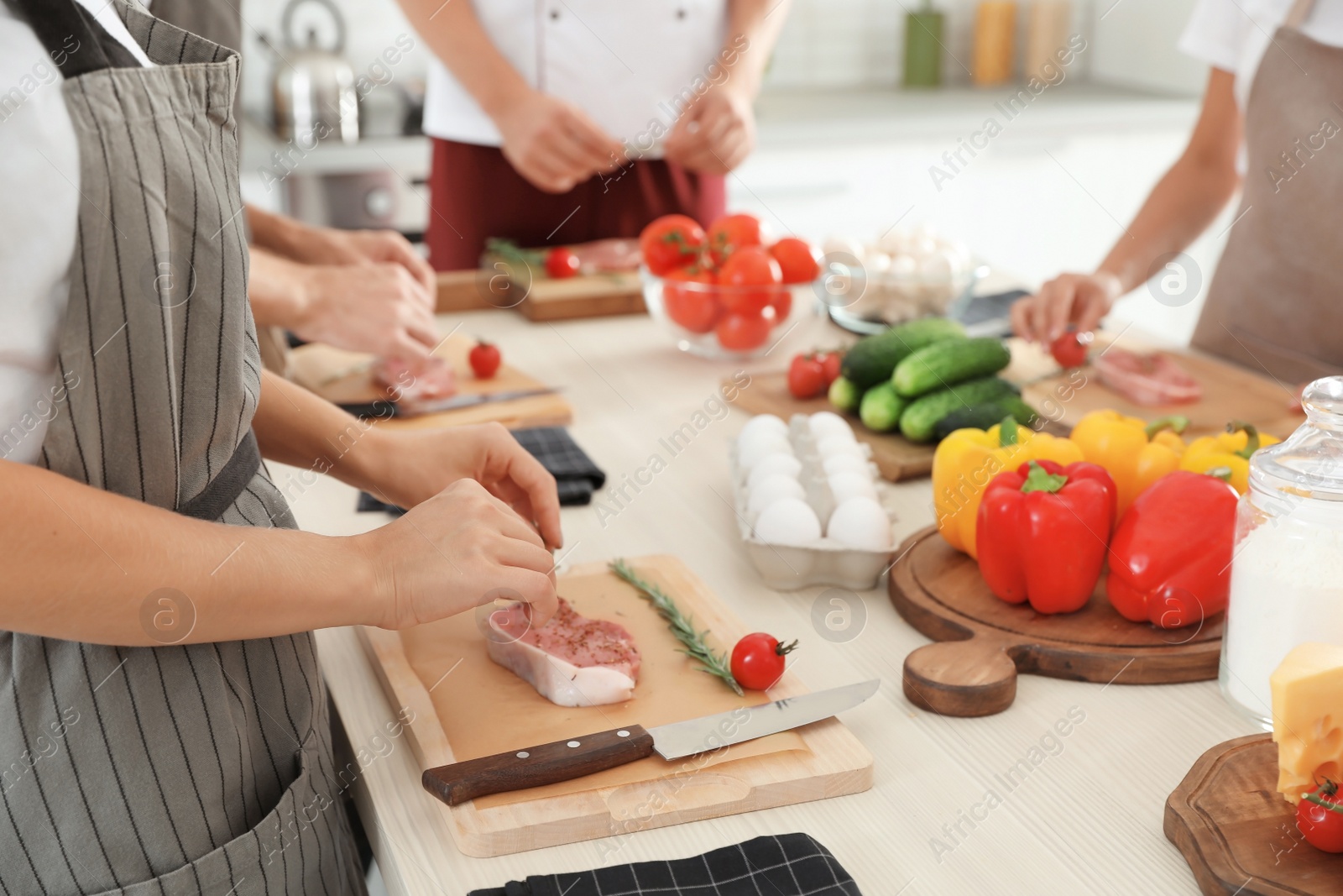Photo of Group of people preparing meat at cooking classes, closeup. Training by professional chef