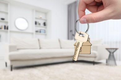 Image of Woman holding house key in room, closeup