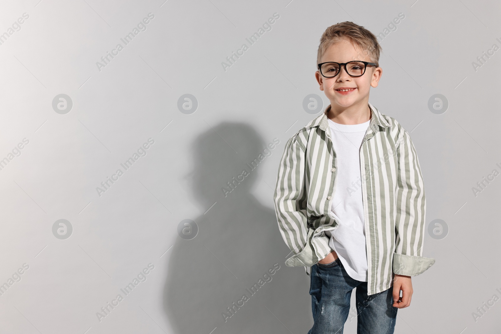 Photo of Fashion concept. Stylish boy posing on light grey background. Space for text