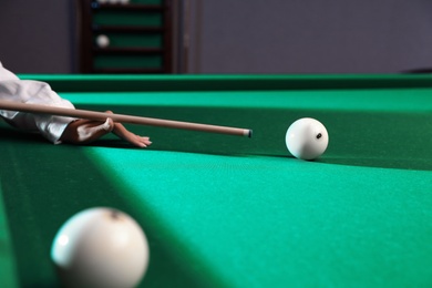 Young woman playing billiard indoors, closeup