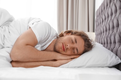 Handsome young man sleeping on pillow at home. Bedtime