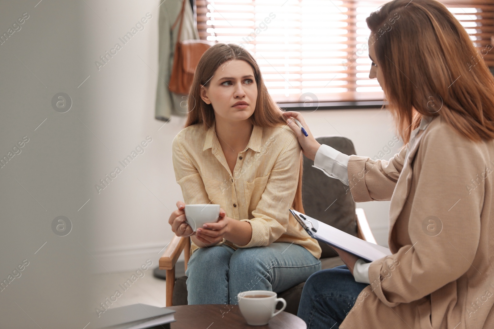 Photo of Professional psychotherapist working with patient in office