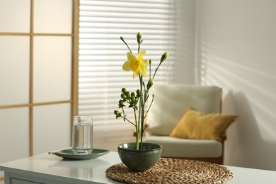 Stylish ikebana with beautiful yellow narcissus flower carrying cozy atmosphere at home