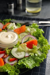 Plate of delicious vegetable salad with mayonnaise served on table, closeup