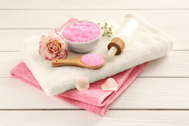 Aromatic sea salt and beautiful flowers on white wooden table