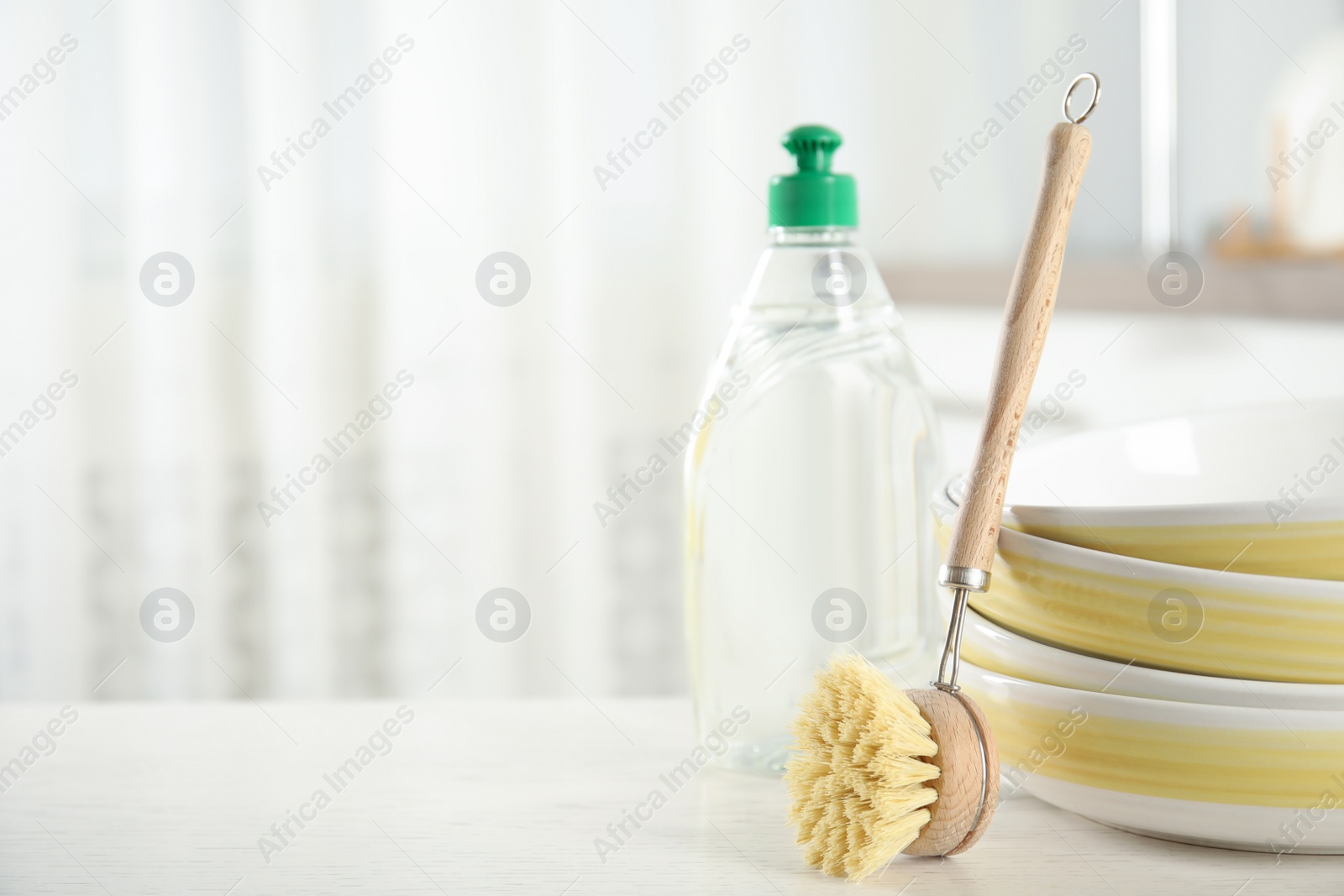 Photo of Cleaning brush near bowls on white table indoors, space for text. Dish washing supply