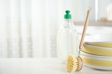 Cleaning brush near bowls on white table indoors, space for text. Dish washing supply