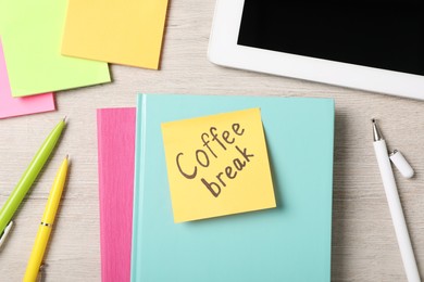 Photo of Sticky note with phrase Coffee Break, stationery and tablet on light wooden table, flat lay