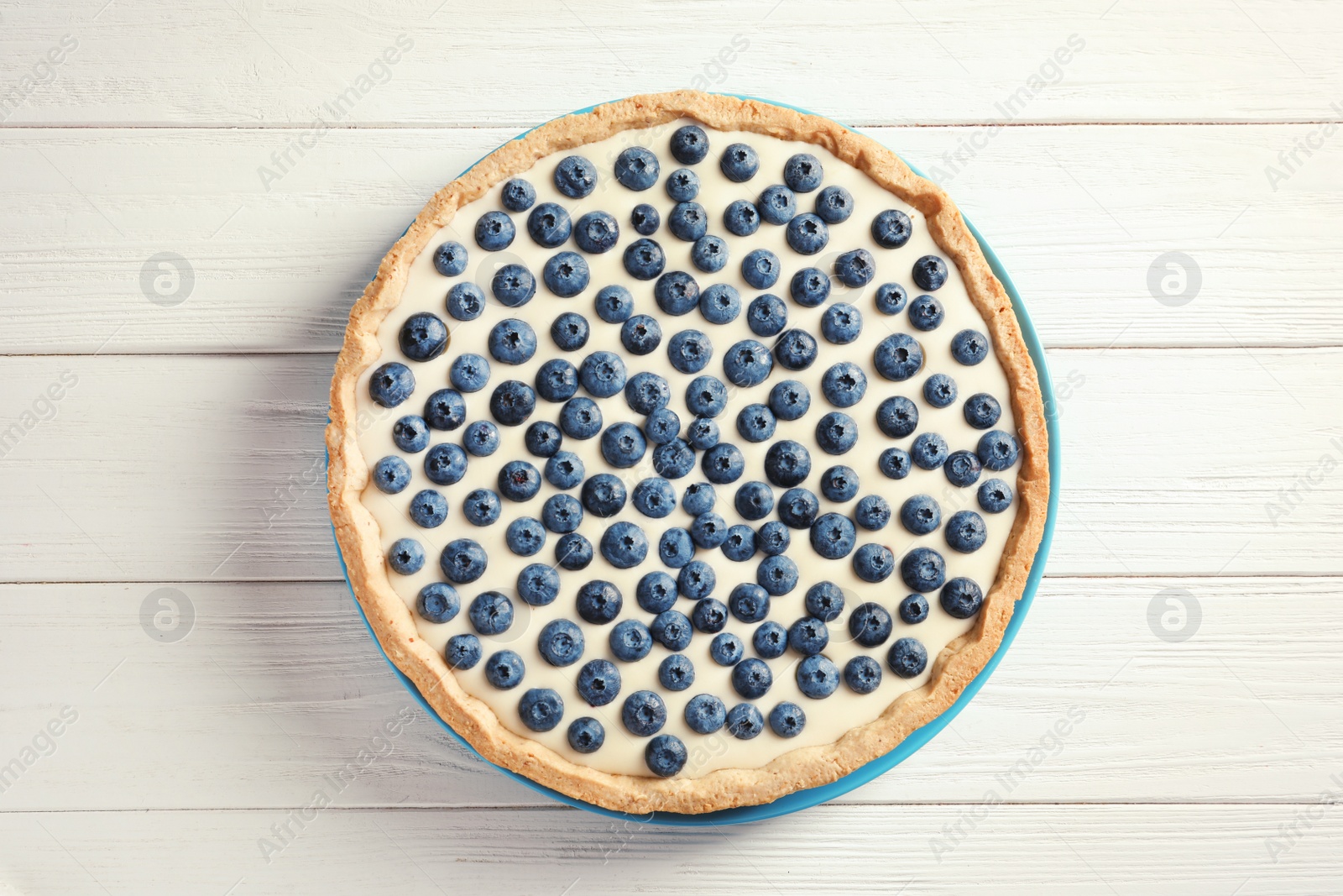 Photo of Tasty cake with blueberry on wooden background, top view