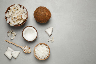 Photo of Flat lay composition with tasty coconut chips on grey table. Space for text