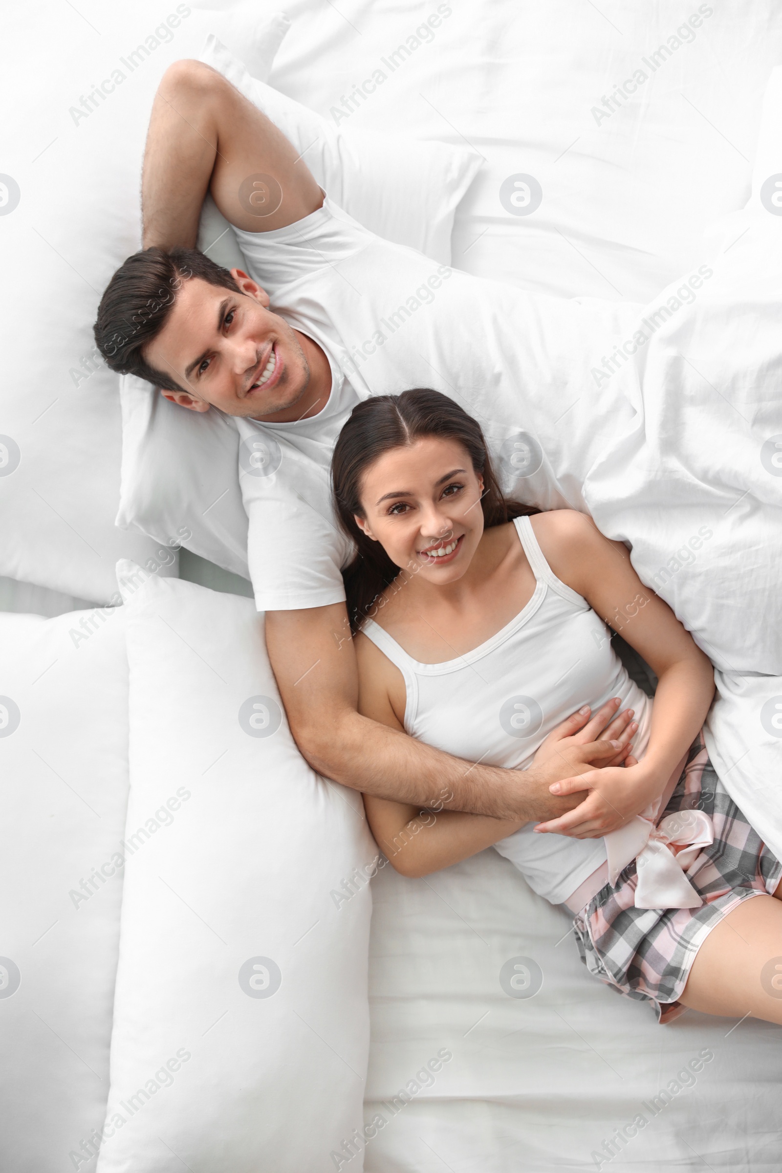 Photo of Lovely young couple resting on large bed, above view