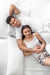 Photo of Lovely young couple resting on large bed, above view