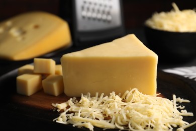 Photo of Grated and cut cheese on table, closeup