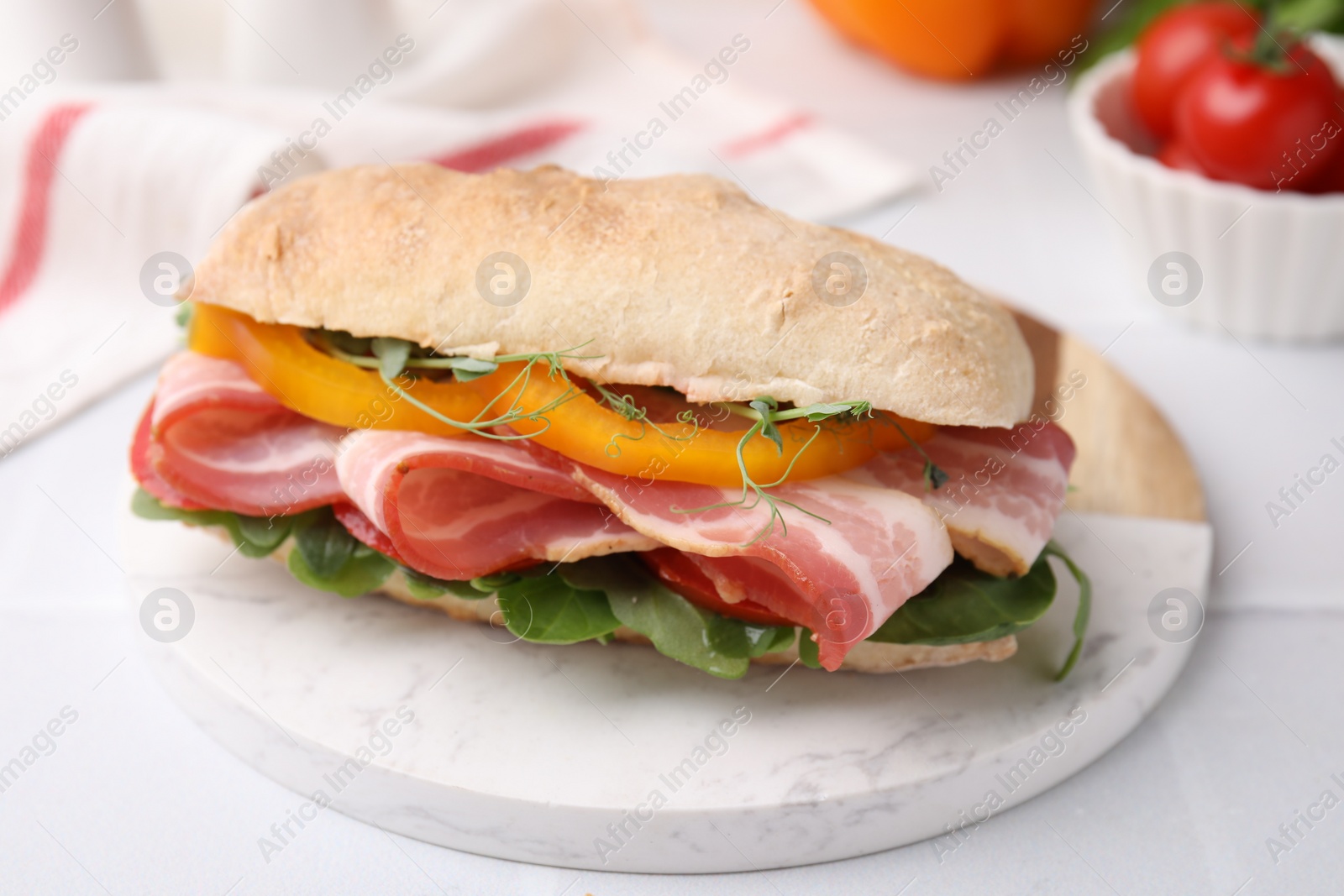 Photo of Tasty sandwich with bacon and bell pepper on white table, closeup