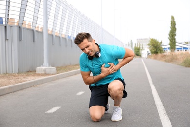 Young man having heart attack while running outdoors