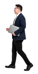 Businessman in suit with laptop walking on white background