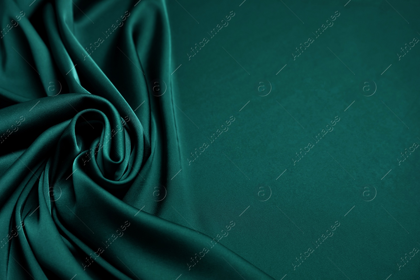 Image of Crumpled dark green silk fabric as background. Space for text