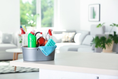 Photo of Basin with cleaning supplies on table indoors