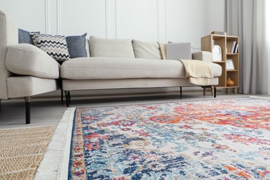 Photo of Stylish living room with beautiful carpet, comfortable sofa and laptop, low angle view. Interior design