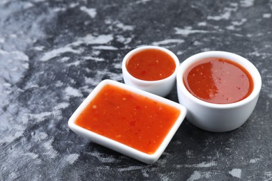 Photo of Spicy chili sauce on black textured table