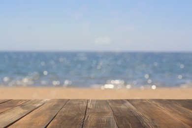 Image of Empty wooden table on beach near sea. Summer season