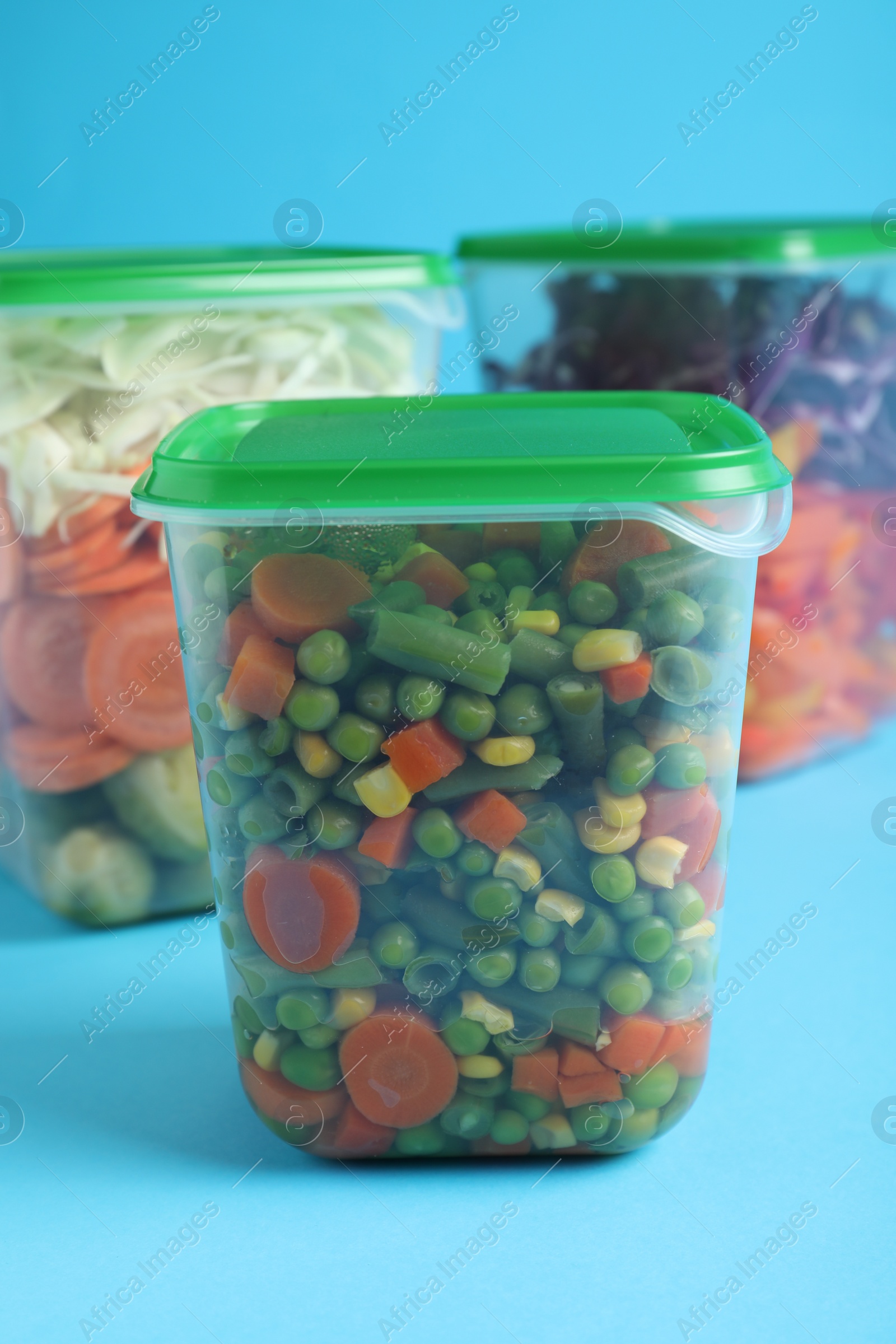 Photo of Set of plastic containers with fresh food on light blue background