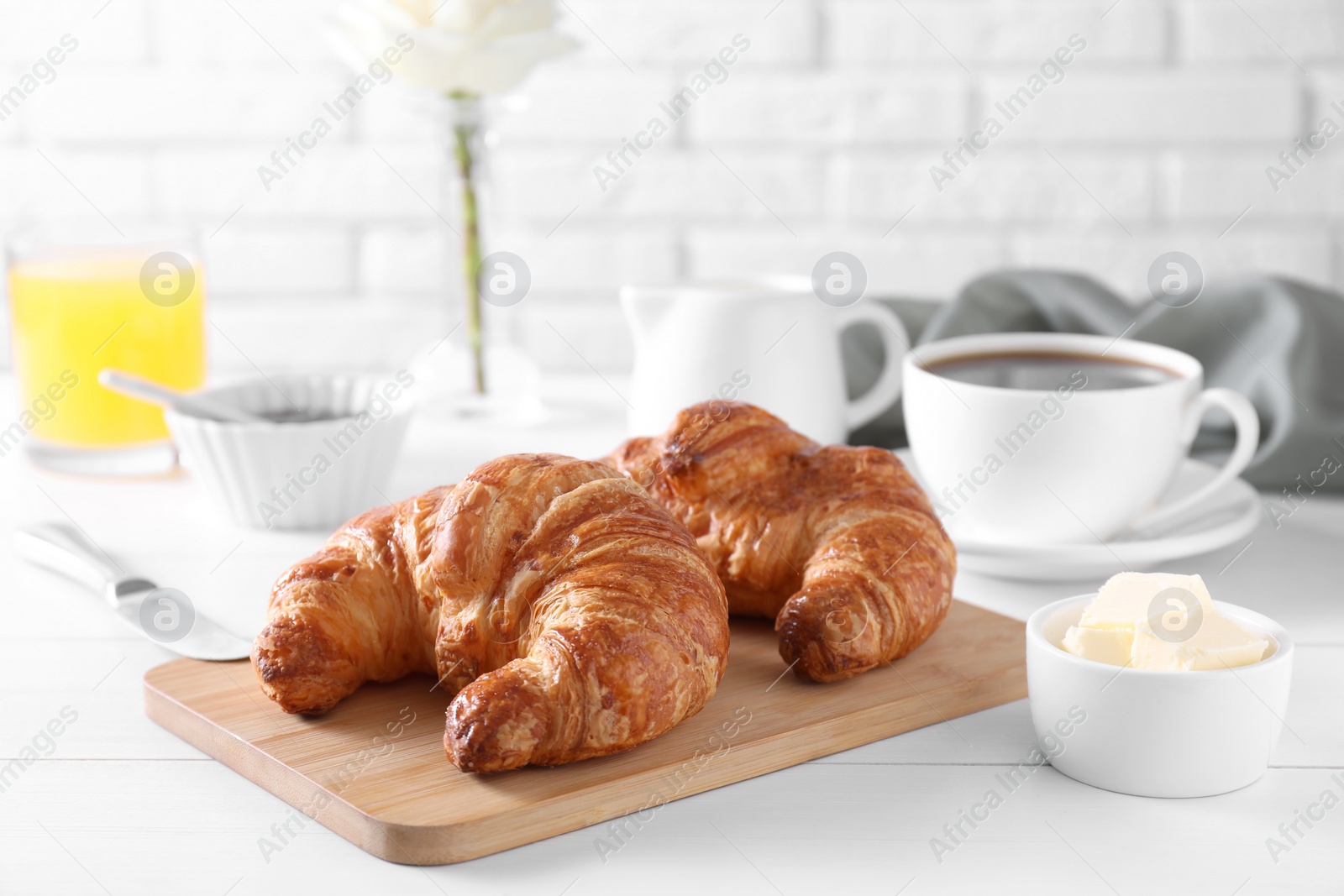 Photo of Fresh croissant and butter on white wooden table. Tasty breakfast